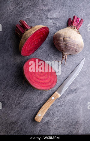 Gustose materie barbabietole. La barbabietola rossa affettata e il coltello sul tavolo da cucina. Vista dall'alto. Foto Stock