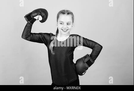 Bambino felice sportivo in guantoni da pugilato. Sport di successo. abbigliamento moda. Dieta Fitness. energia salute. allenamento di piccola ragazza boxer. knockout di punzonatura. Attività dell infanzia. Felice e sportivo. Foto Stock