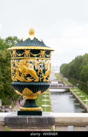 Al Parco di Peterhof, San Pietroburgo, Russia, agosto 2019. Un grande vaso decorato nella parte anteriore del canale principale del parco circondato il grande palazzo Foto Stock