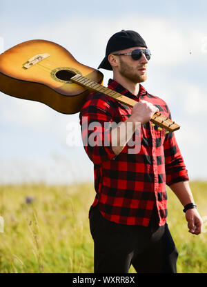 Uniti con la natura. Ispirando la natura. Uomo bello con la chitarra a contemplare la natura. In cerca di muse. La vacanza estiva. Trasognata wanderer. Atmosfera pacifica. Escursionismo canzone. Un musicista in cerca di ispirazione. Foto Stock