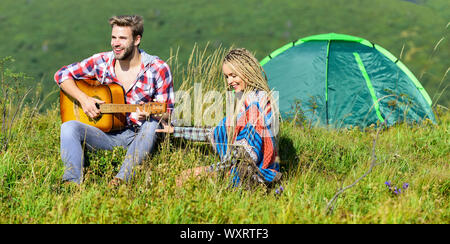 Escursionismo romance. Campeggio in montagna. Aria fresca e sentimenti puri. Matura in amore felice natura rilassante sfondo. Ragazzo ragazza chitarra vicino camping tenda. La vacanza estiva. Vacanza in campeggio. Foto Stock