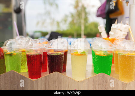 Un contatore con multi-colorati cocktail di frutta in bicchieri di plastica. Il cibo e la cucina Attrezzature in una street food festival. Foto Stock