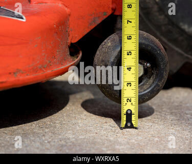 Prato del pianale del tosaerba e anti-cuoio capelluto ruota di livello con nastro di misurazione controllo regolazione altezza. prato riparazione e manutenzione di apparecchiature concept Foto Stock