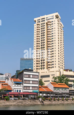 Singapore - Marzo 21, 2019: dal Fiume Singapore. Riverwalk appartamento torre dietro la fila di ristoranti e bar sotto il cielo blu. Aggiungere piante verdi. Foto Stock