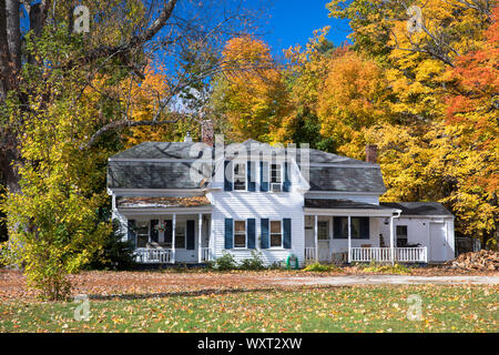Neat tradizionale in legno tipico Bianchi infissi casa circondata dalla caduta delle foglie, in Conway, New Hampshire, STATI UNITI D'AMERICA Foto Stock