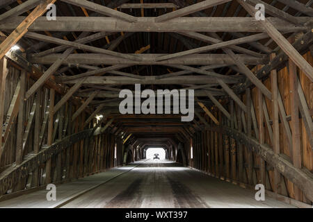 A capriate e travi in forme geometriche e car guida attraverso il ponte coperto in New Hampshire, STATI UNITI D'AMERICA Foto Stock