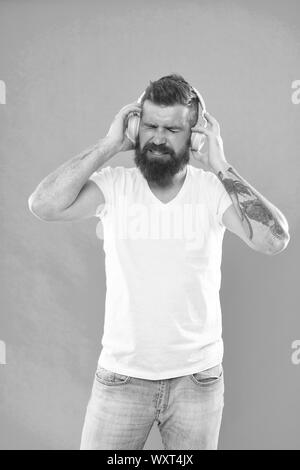 L'uomo nelle cuffie. Gratis Online le sorgenti musicali tutti funzionano in modo leggermente diverso e hanno molte caratteristiche differenti. Diagramma di musica. Coppia hipster con la barba ascoltando musica. Elegante e bello amante della musica. Foto Stock