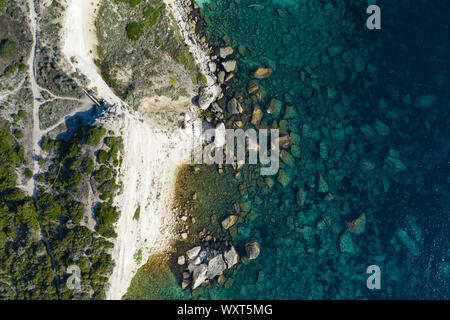 Vista da sopra, splendida vista aerea a una bianca roccia calcarea e formazioni rocciose bagnate da un turchese chiaro acqua, Bonifacio, Corsica, Francia. Foto Stock