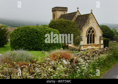 San Barnaba chiesa anglicana con cimitero e fiori selvatici a muro di pietra in wet tempo piovoso in Snowshill Cotswold Inghilterra Foto Stock