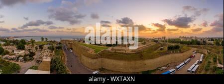 Antenna vista al tramonto di Acco centro storico medievale con Al Jazzar mosque crusader e ottomano mura, bazaar arabi e cielo arancione Foto Stock