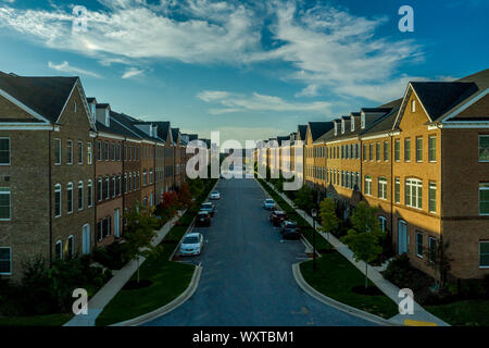 Immobiliare americano quartiere street in Maryland con tipici della costa est facciata in mattoni townhouses con blu cielo nuvoloso vista aerea Foto Stock