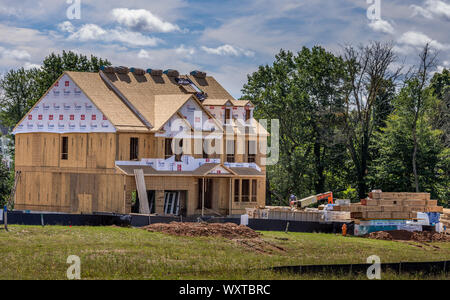 Tipico americano unica famiglia telaio della casa in costruzione con tetto di legno compensato, abbaini Foto Stock