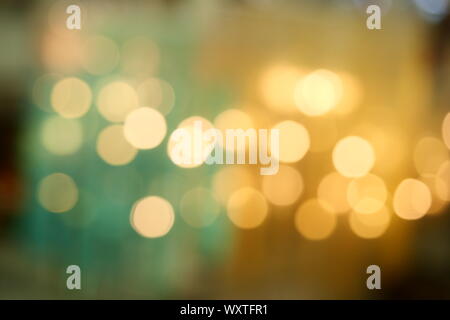 Bokeh da illuminazione per interni, colorati cerchi di luce diffusa su blu di colore giallo e con sfondo verde per la celebrazione delle feste Foto Stock