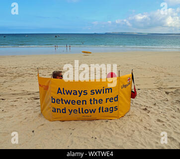 Una tranquilla giornata fuori stagione a St Ives, ma i bagnini sono sul dovere di tenere al sicuro tutti noi Foto Stock