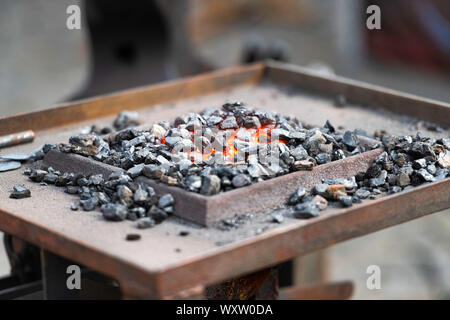 La combustione di carbone in un fabbro del workshop Foto Stock