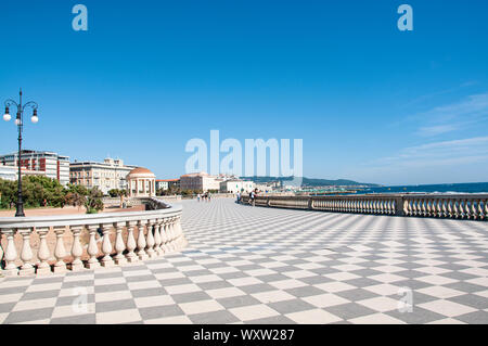 Basso angolo vista della pavimentazione a scacchiera sul lungomare della Terrazza Mascagni a Livorno, Toscana, Italia come esso si incurva lungo il lungomare su un soleggiato Foto Stock