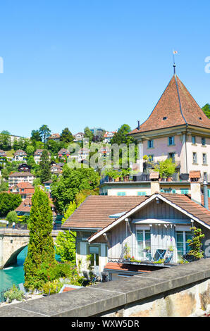 Bern, Svizzera - 14 agosto 2019: edifici storici situati lungo il turchese del fiume Aare nel centro storico della capitale della Svizzera. Catturato sulla fotografia verticale durante la soleggiata giornata estiva. Foto Stock