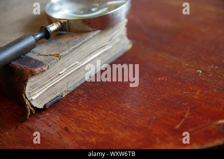 Lente di ingrandimento e vecchio libro Foto Stock