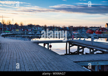 Passerella in legno jetty boardwalk intorno a Sandhamn porto al tramonto, Sandhamn, arcipelago di Stoccolma, Svezia Foto Stock