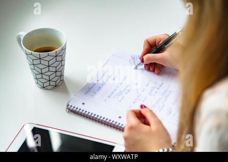 Immagine closeup della mano di donna che scrive sul notebook Foto Stock