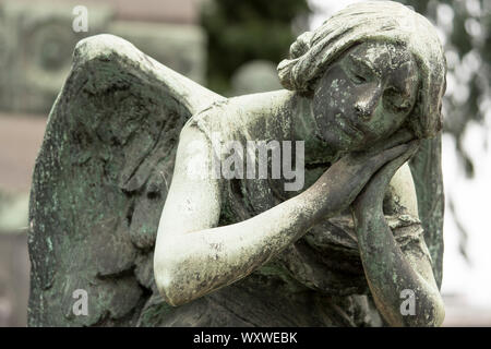 Angelo statua di pietra su una tomba nel Cimitero Monumentale (cimitero monumentale), uno dei due più grandi cimiteri in Milano, Italia Foto Stock