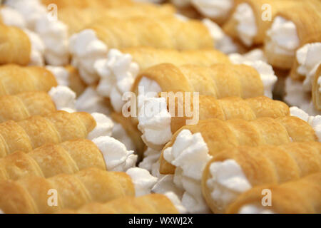 Pasta sfoglia i rotoli per il dessert kremrole - impilati rotoli di schiuma o Schillerlocken Schaumrollen per pasticceria Foto Stock