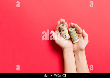 Vista dall'alto di dollari nelle femmine di palme su sfondo colorato. Piccola pensione concetto. Foto Stock