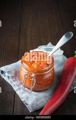 Adjika tradizionale hot chili pepper pasta salsa Harissa. La Tunisia, georgiano e cucina araba. Orientamento verticale. Spazio per il testo. Foto Stock