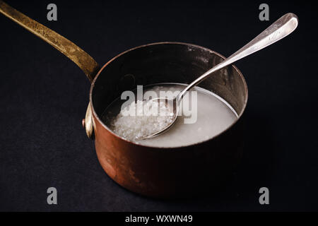 Il risciacquo riso arborio nella pentola di rame Foto Stock