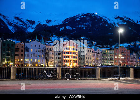 Inverno Innsbruck di notte. Colorato luminoso edificio fulmini e mountines, coperto di neve. Austria, Tirolo. Foto Stock