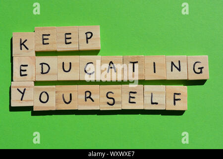 Mantenere educare se stessi. Parole motivazionale, utilizzando l'acronimo chiave. Alfabeto di legno lettere su un brillante sfondo verde Foto Stock