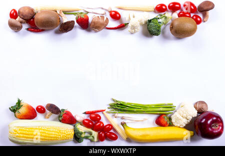 La Giornata mondiale dell'alimentazione o la Giornata Vegetariana concetto. Vista dall'alto di verdure fresche, frutta, erbe e spezie con un vuoto sul libro bianco sullo sfondo. Foto Stock