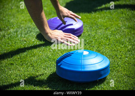 Close-up delle mani di un uomo che è di formazione e facendo push-up con equilibrio il vassoio Foto Stock