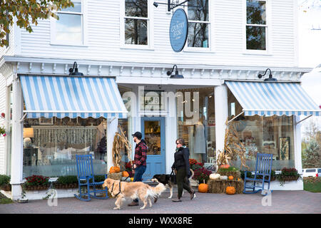 La gente locale cani a piedi passato il paese Store sulla strada principale di Stowe Vermont, USA Foto Stock