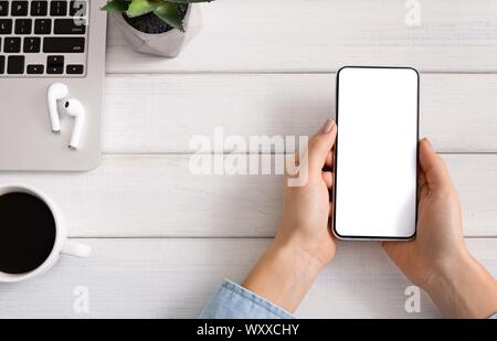 Donna che utilizza smartphone per ascoltare musica online in erphones Foto Stock