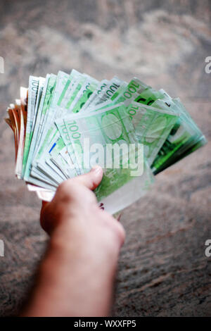 Close up di un maschio di mano che trattiene le banconote in euro Foto Stock