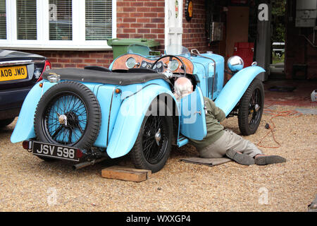 Vista di uomo anziano lavora su blue vintage Morgan auto da 1930s Foto Stock