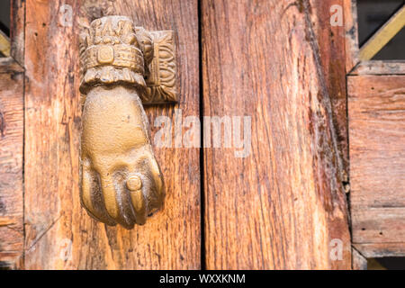 Vecchio a mano a forma di manopola per bussare a una vecchia porta di legno. Foto Stock