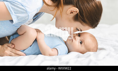 Giovane madre guardando il suo neonato con adorazione Foto Stock