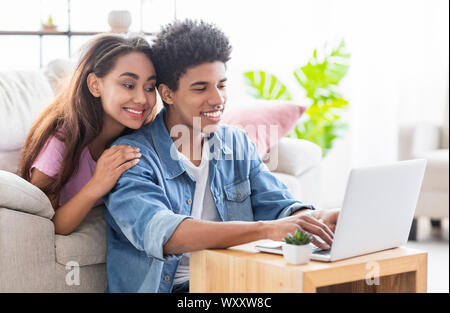 Felice african teen giovane lavorando insieme sul portatile a casa. Foto Stock