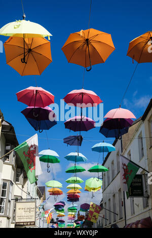 Installazione d arte colori di visualizzazione di ombrelli appeso sopra una stradina nel centro storico. Palace Street (Stryd y Plas) Caernarfon Gwynedd Wales UK Foto Stock