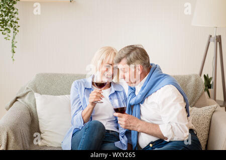 Celebrare l'anniversario. Felice coppia senior di bere il vino in casa Foto Stock