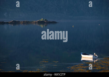 Barche in Lochcarron con drammatica mattina presto luce con uno sfondo scuro creato dalla collina riflessa attraverso il loch. Foto Stock