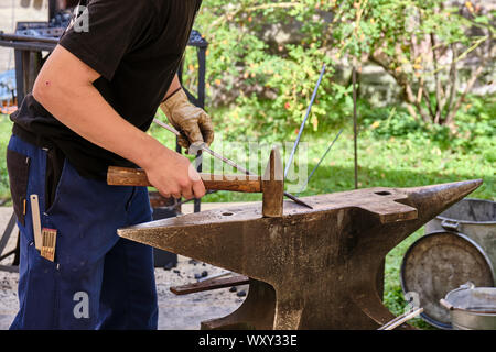 Sezione mediana del fabbro formando ferro con un martello e l'Incudine Foto Stock
