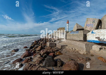 Il lapidato shore vicino al faro. Lettonia Foto Stock