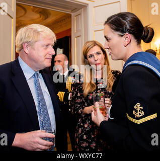 Il primo ministro Boris Johnson parla ad un ospite che ospita un ricevimento militare, con il suo partner Carrie Symonds (centro), al 10 Downing Street, Londra. Foto Stock