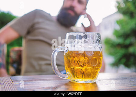 Bere da una tazza per tenere saldamente in mano. Boccale di birra. Servire refrigerate birra in tazza di vetro nel pub. Grande tazza di una bevanda rinfrescante sulla outdoor cafe tabella. Per avere e per contenere e mantenere la vostra birra fredda. Foto Stock