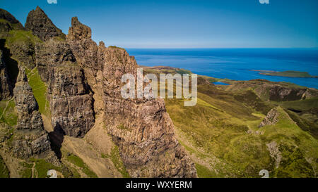 Il drammatico pilastri verticali di rocce agaings il mare blu sotto il cielo chiaro sull isola di Skye Foto Stock