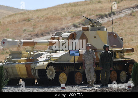 (190918) -- DUSHANBE, Sett. 18, 2019 (Xinhua) -- soldati stand da un semovente di artiglieria 2S3 durante il centro-2019 esercitazione militare nella regione di Dushanbe, Tagikistan, sul Sett. 18, 2019. Tsentr-2019 (Centro-2019) esercitazioni militari che coinvolge otto paesi iniziata lunedì in Russia, Kazakistan e Tagikistan, Ministero della Difesa russo ha detto in una dichiarazione il martedì. Un totale di 128.000 truppe, più di 20.000 unità di armi ed equipaggiamenti militari, circa 600 velivoli e fino a 15 navi e navi di sostegno prenderà parte a trapani su diversi motivi di formazione nei tre paesi un Foto Stock