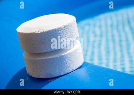 Pellet di cloro sul bordo di una piscina gonfiabile Foto Stock